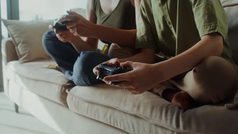 mother and son playing video games on a couch