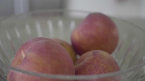 Closeup-of-fresh-peaches-in-a-bowl-on-a-kitchen-table