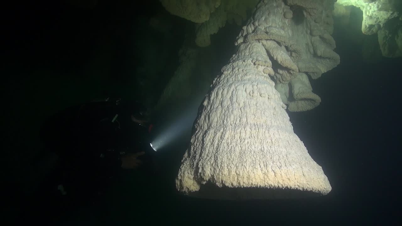 buceador de cuevas y espeleotemas de campana únicos