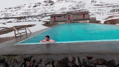 view at man swimming in abandoned outdoor pool surrounded by mountains