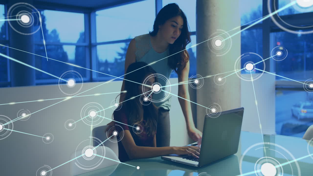 Two women working on laptop with network connections animation overlay