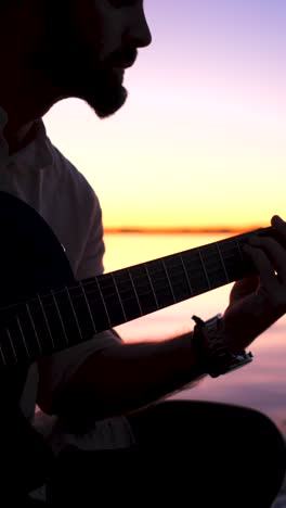 musician playing guitar at sunset