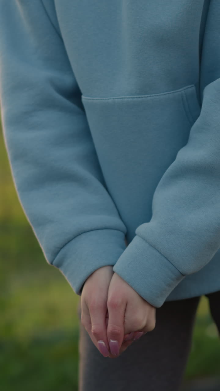 잘 은 손을 가진 배구 선수가 배구 경기를 준비하는 클로즈업, 배경에는 울창한 개방된 경기장과 스포츠 환경이 있으며, 운동과 스포츠 훈련을 보여줍니다.