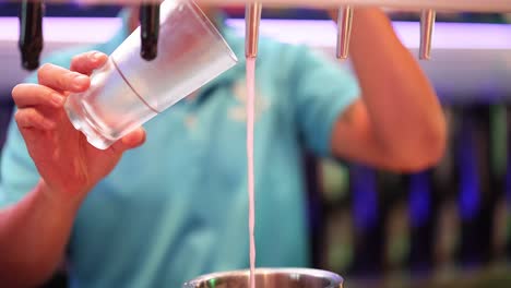 bartender pours beer into a glass