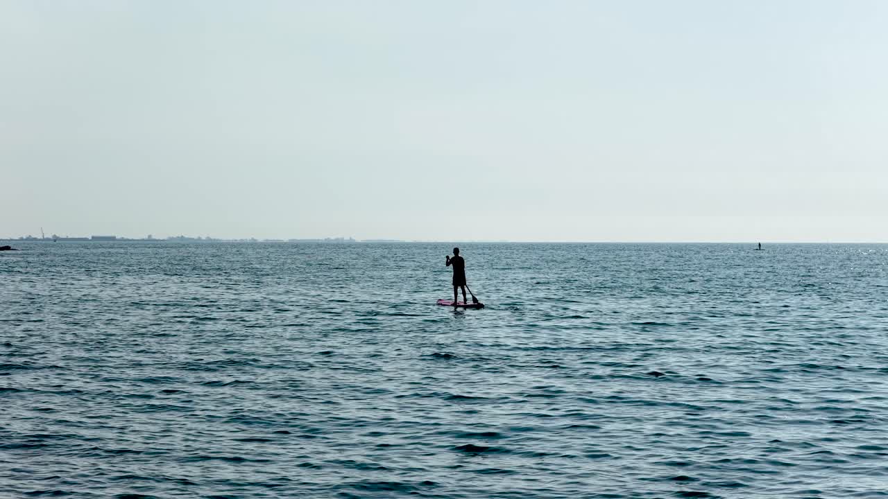 Man paddle boarding in calm ocean waters