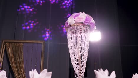 a creatively lit flower arrangement sitting on a table at a reception hall