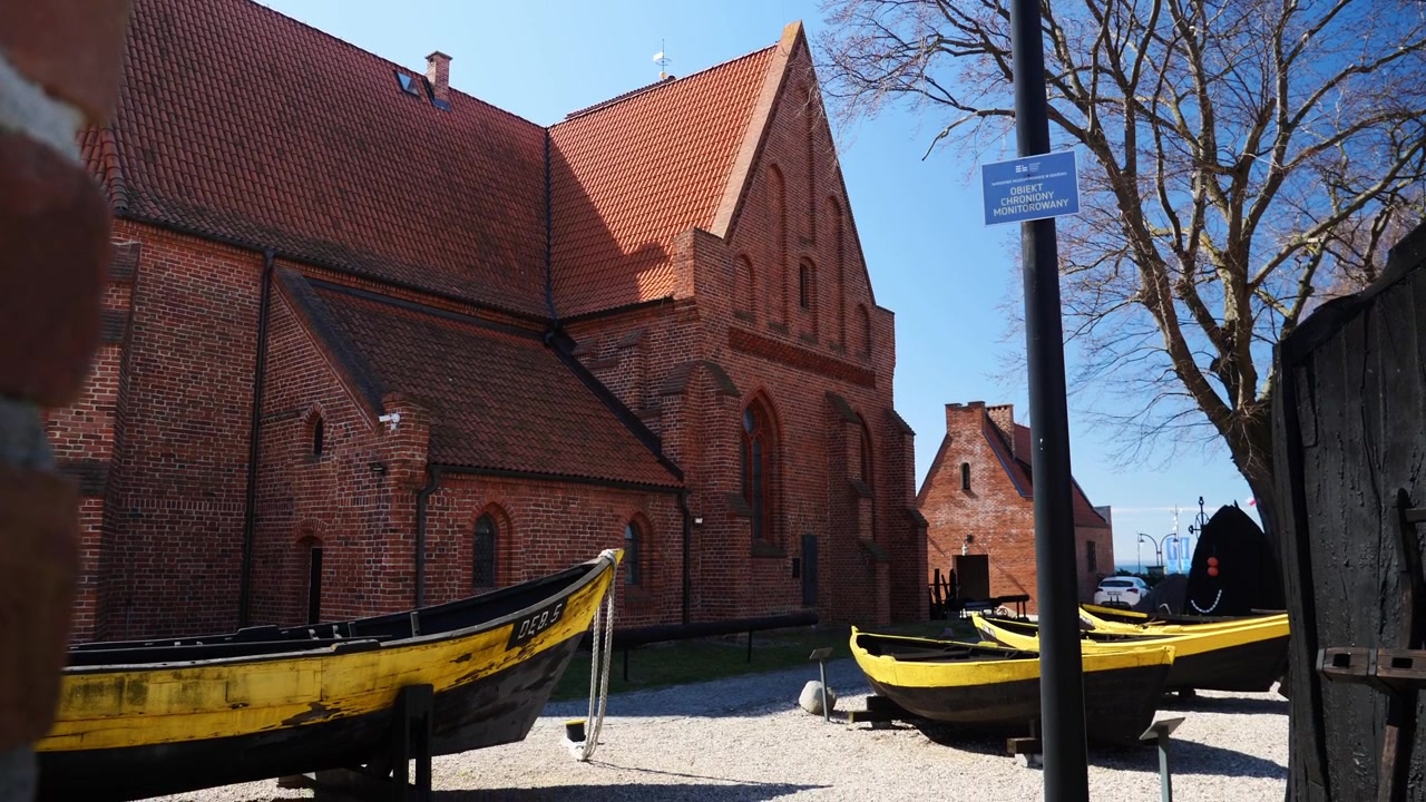 La telecamera si inclina verso il basso per rivelare storiche barche da pesca in legno esposte all'aperto al Museo della Pesca a Hel, Polonia, mettendo in mostra il ricco patrimonio marittimo della costa baltica.