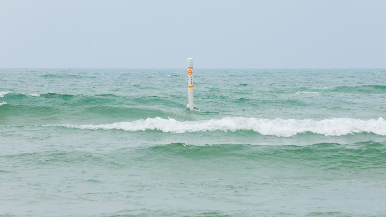 미시간 호수 의 해변 근처 에 있는 수영 마커 를 지나가는 큰 파도