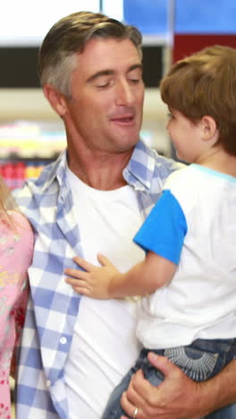 familia feliz divirtiéndose mientras hace compras
