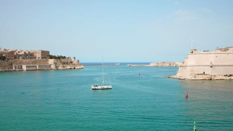 Seascape-view-with-alone-yacht-and-medieval-cities-in-Malta---static-wide-shot