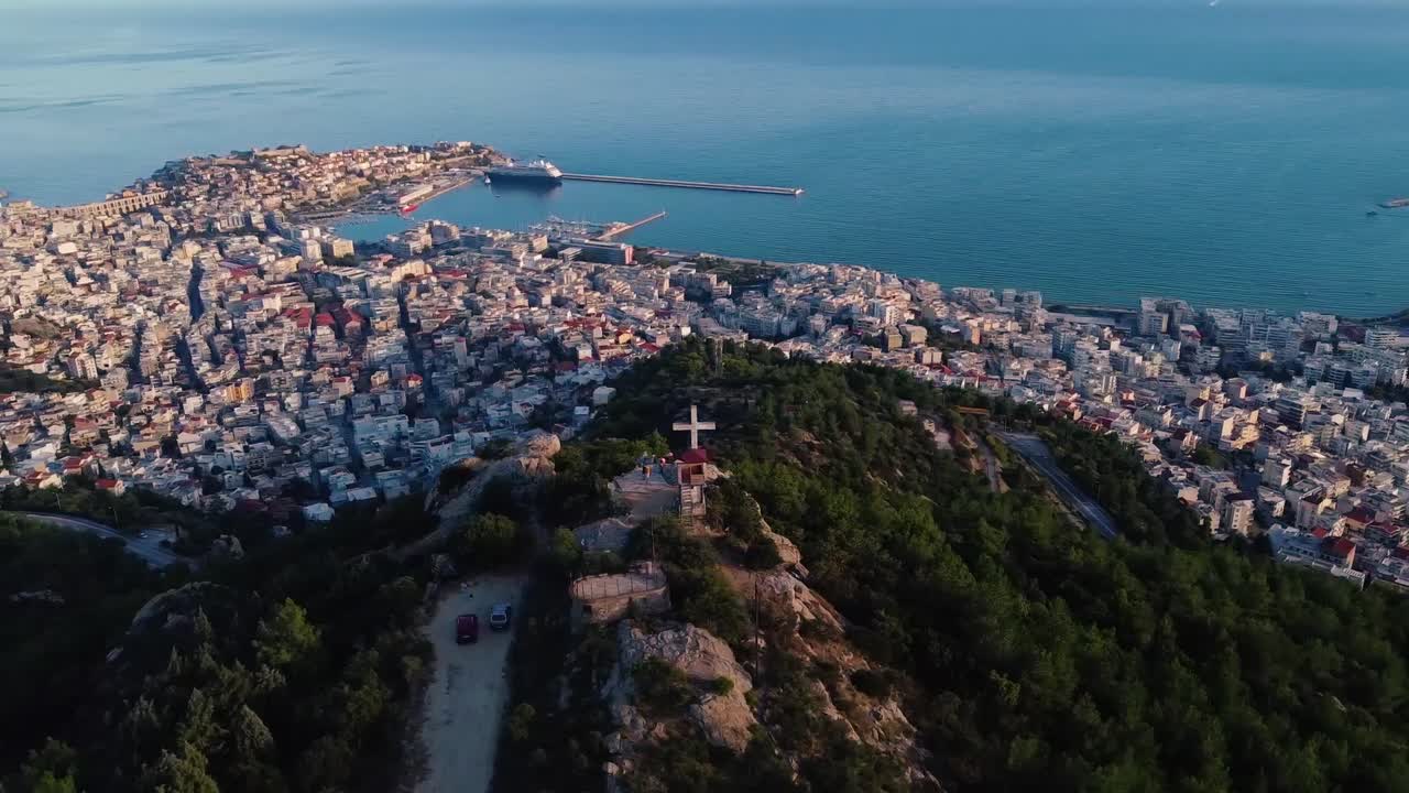círculo aéreo sobre la cima de la montaña con cruz al atardecer