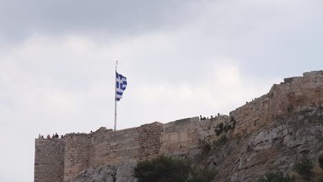 bandera griega ondeando en la acrópolis de atenas