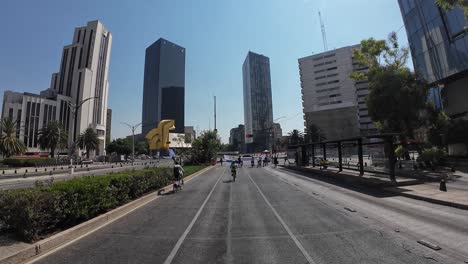 shot of a woman with her bicycle in reforma avenue mexico city at morning