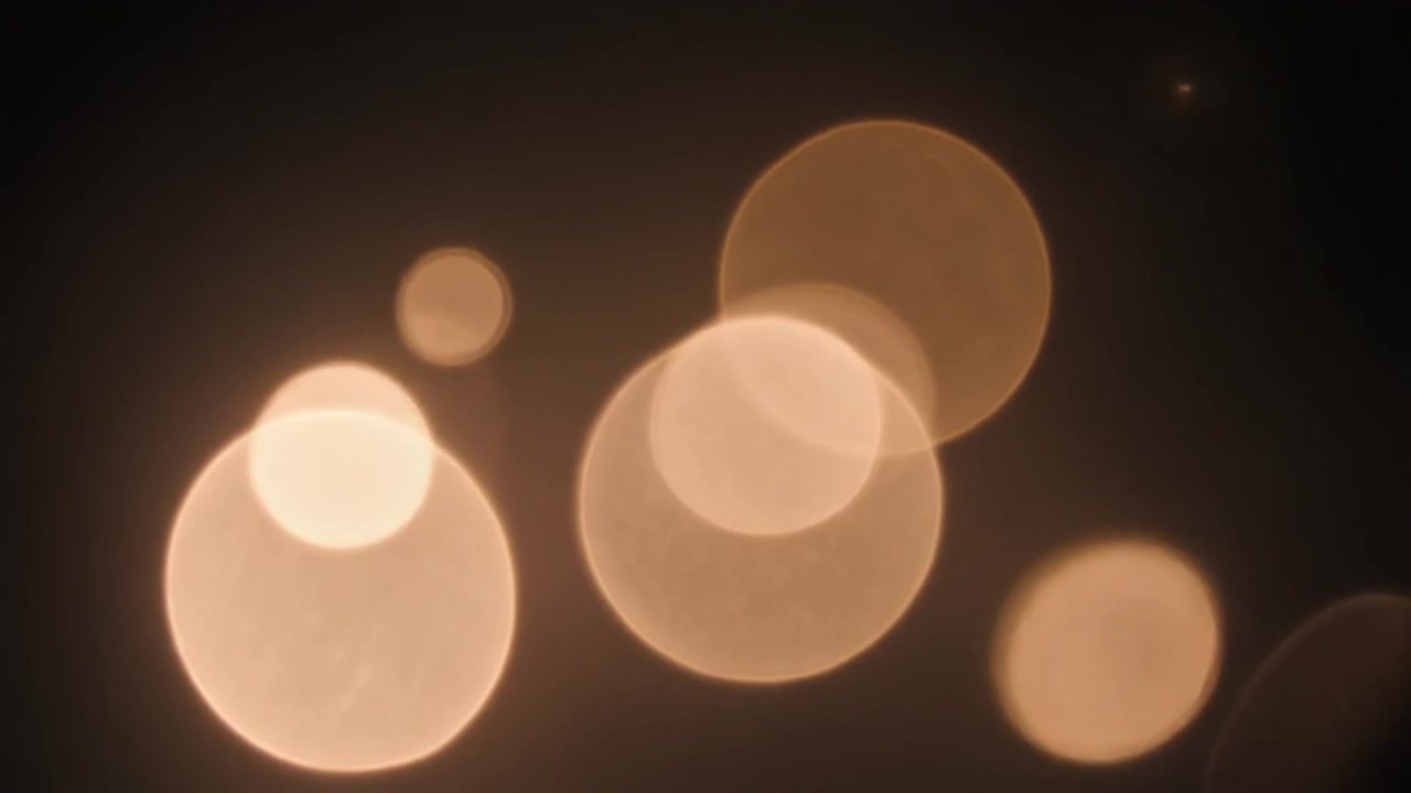 Abstract Golden Bokeh Lights Floating on Dark Background
