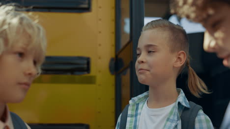 Three-teen-children-standing-at-open-bus-door-closeup.-Boys-talking-together.