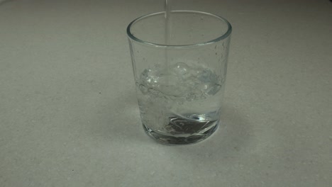 a glass of clean cold fresh healthy spring water being poured