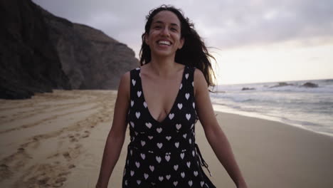 Young-happy-smiling-latin-black-woman-walking-in-slow-motion-on-sandy-beach-with-scenic-ocean-seascape-in-background,-tropical-paradise,-summer-holiday-destination