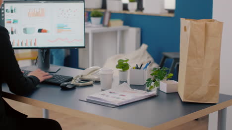 executive manager carrying paper bag with takeaway food lunch order putting on desk