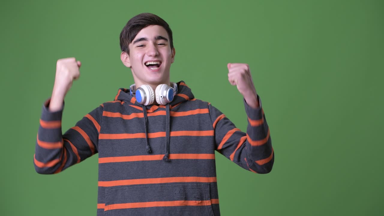 초록색 배경에 젊은 잘생긴 이란 십대 소년