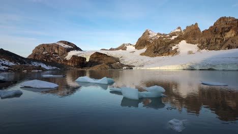 cena matinal pacífica no lago glacial ao lado da geleira claridenfirn em uri, suíça, com o alpenglow dos picos alpinos refletido e icebergs flutuando em primeiro plano