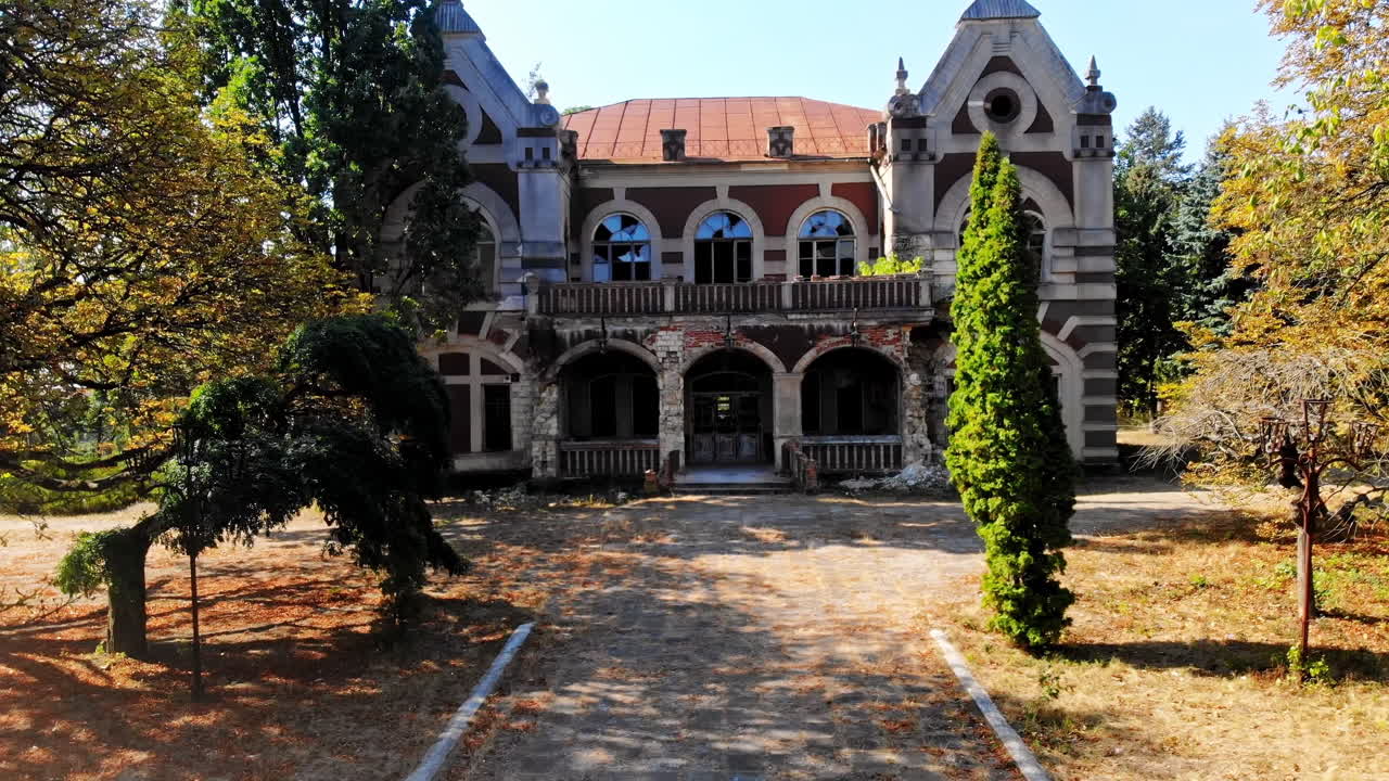 The Pommer Mansion, old abandoned building with green trees and benches on the yard. Aerial drone view. Țaul, Moldova