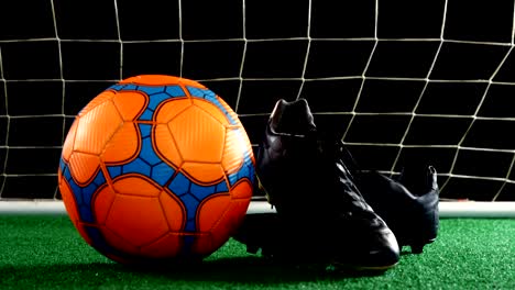 close-up of football and cleats on artificial grass 4k