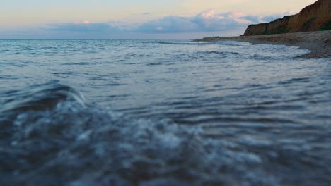 seawater waves splashing rocky coastline at sunset cloudy sky. relaxation travel