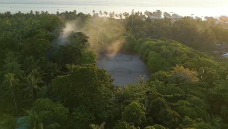 Aerial-revealing-shot-of-a-football-field-in-the-Bajau-Laut-community-during-sunset