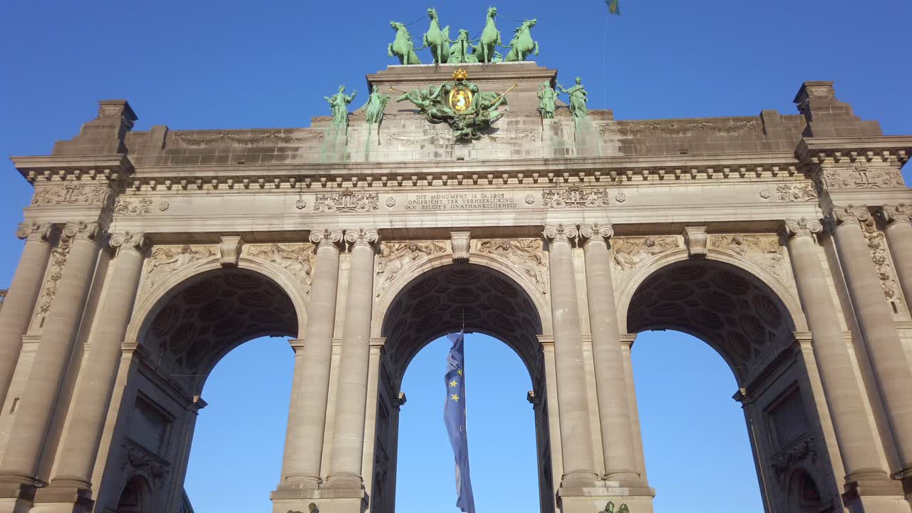 European Union flag waving under Brussels Cinquantenaire arch