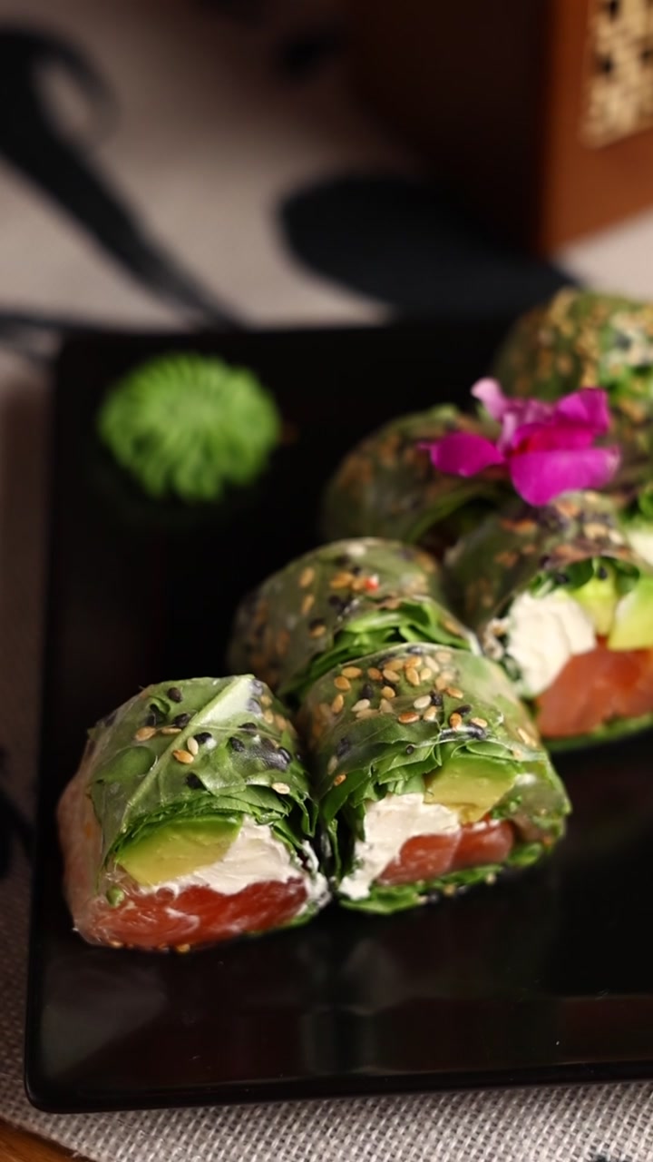 Involtini di Carta di Riso con Salmone Fresco e Avocado su Piatto Nero