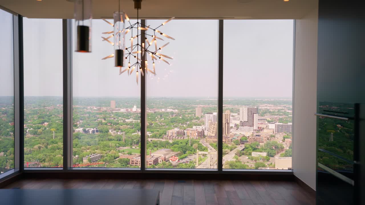 panorámica desde el interior de un apartamento de gran altura, capturando la vista a través de las ventanas al paisaje de abajo