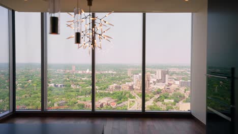 panning shot from inside a high-rise apartment, capturing the view through windows to the landscape below