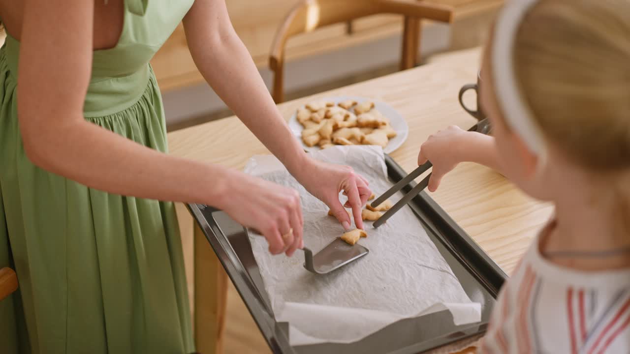 어머니와 딸이 쿠키를 고 있습니다.