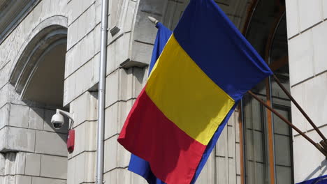 romanian flag on building in bucharest slowly waving in the wind, day