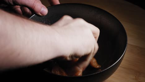 mezcla a mano la pechuga de pollo en rodajas en un tazón, sazonada con sal, pimienta negra, paprika, ajo en polvo y aceite de oliva