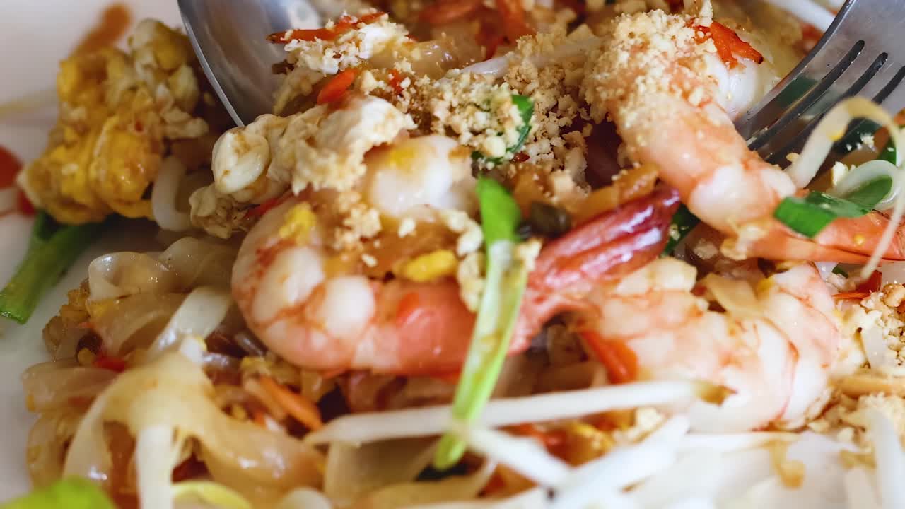 Detailed view of shrimp Pad Thai with noodles, peanuts, and bean sprouts.