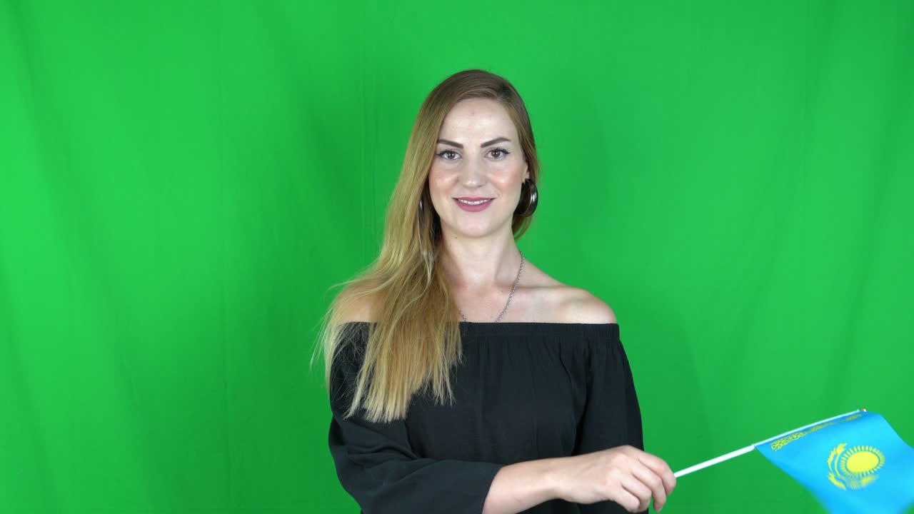 mujer rubia agitando delante de la bandera de kazajstán pantalla verde, fondo clave de croma