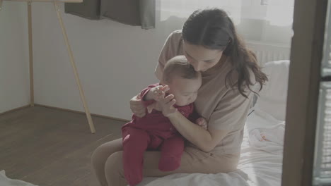 Mom-And-Cute-Baby-In-Her-Arms-At-Home