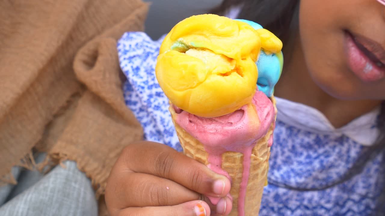 маленькая девочка ест рожок мороженого