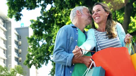 Mature-man-is-kissing-his-wife-in-the-street-after-shopping