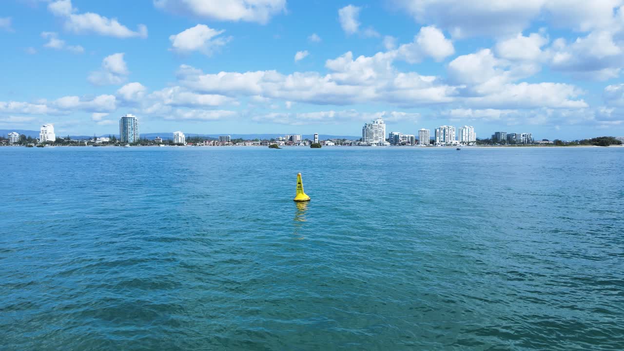 revelando una boya amarilla de marcador de límite de velocidad marina se encuentra anclada en aguas tranquilas de una importante zona fluvial