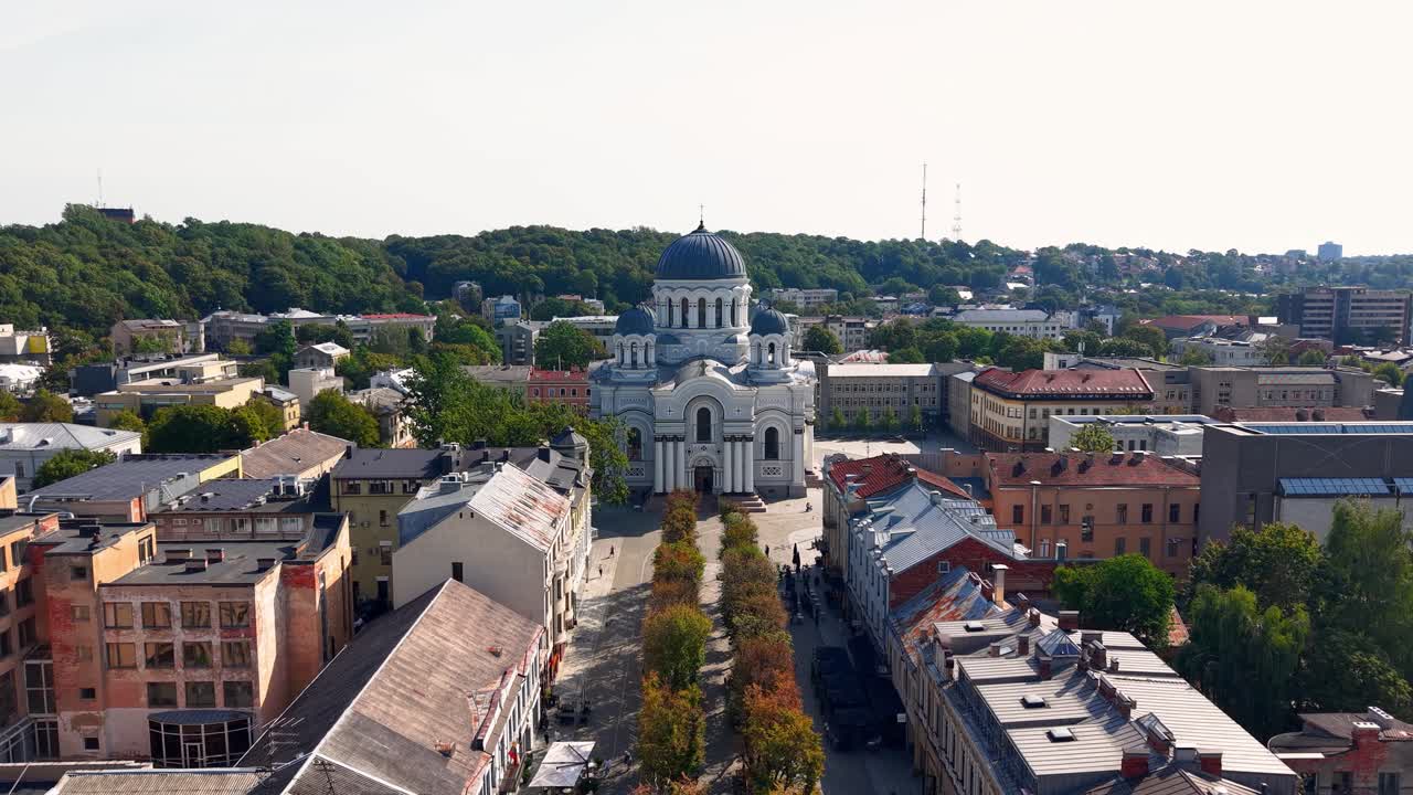 Aerial view of Laisvės Alėja pedestrian street leading to the iconic St. Michael the Archangel Church in Kaunas, Lithuania, surrounded by city buildings and greenery