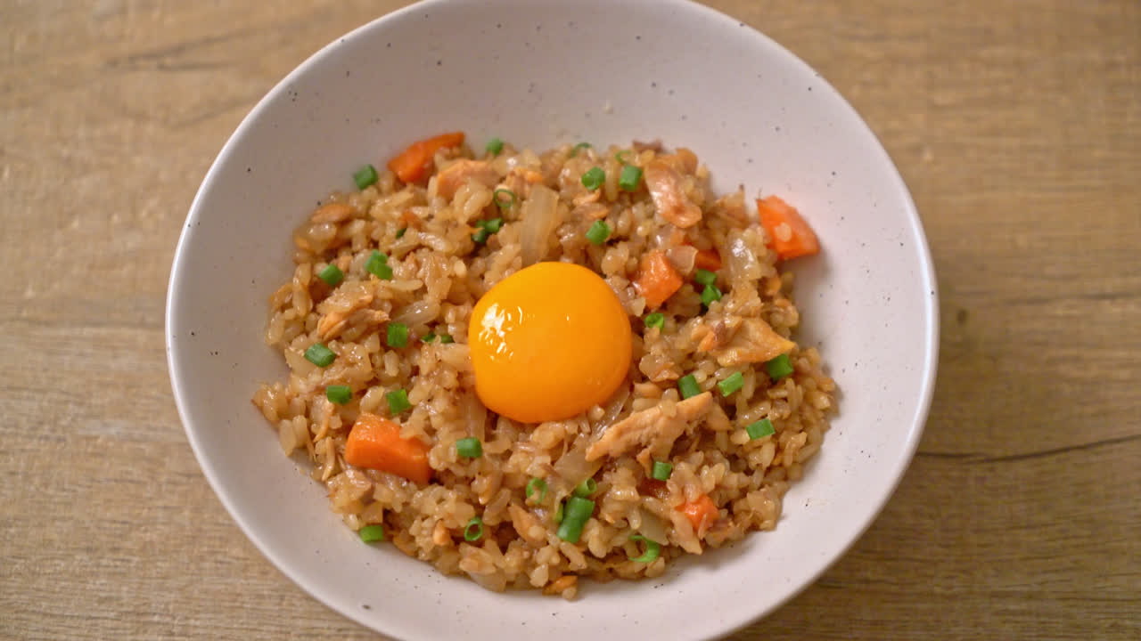 arroz frito con salmón con huevo en escabeche encima - estilo de comida asiática