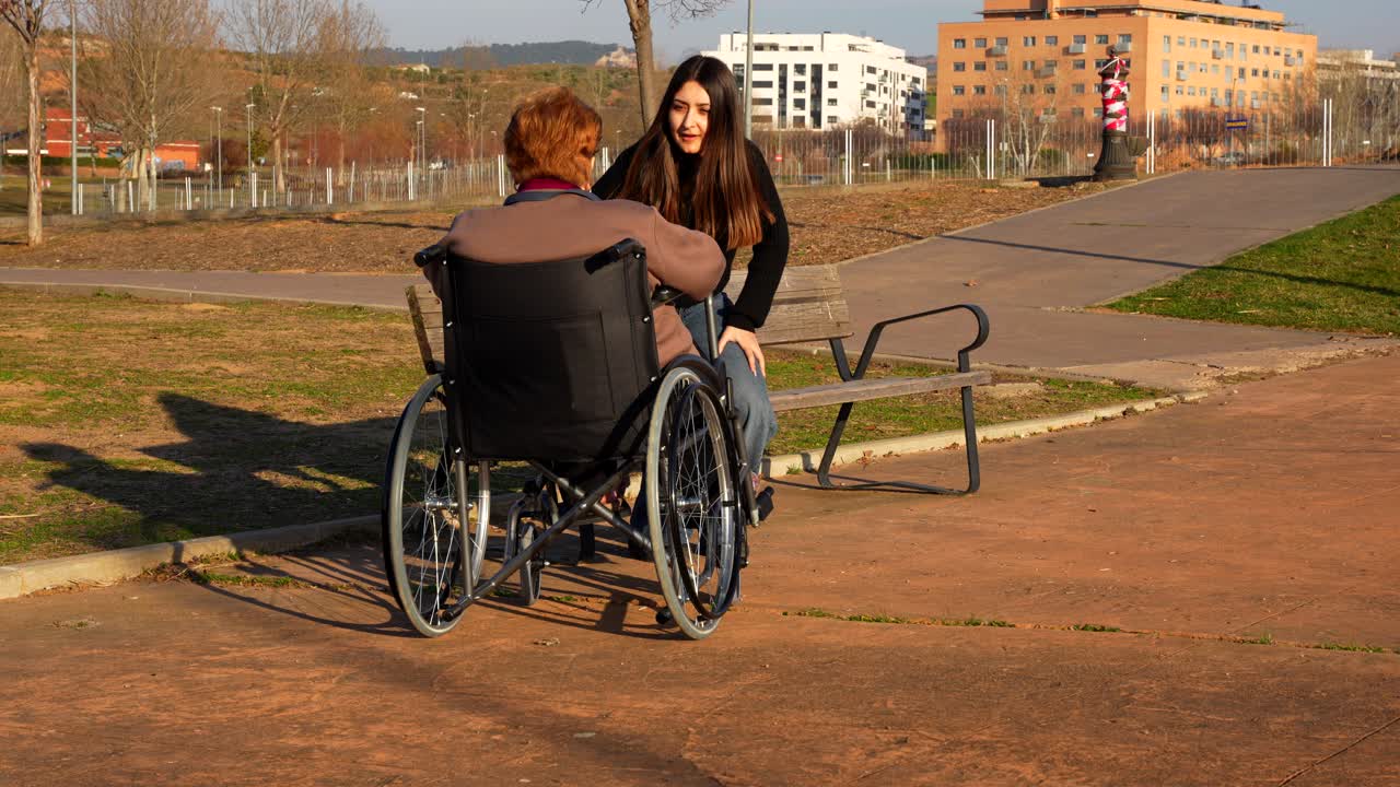 Granddaughter approaches her granny to a bench to talk to her