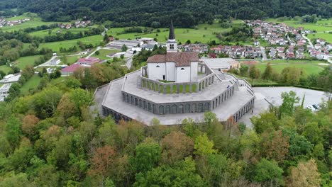 aerial drone shot of a church on a hill with mountains in the background, 4k uhd