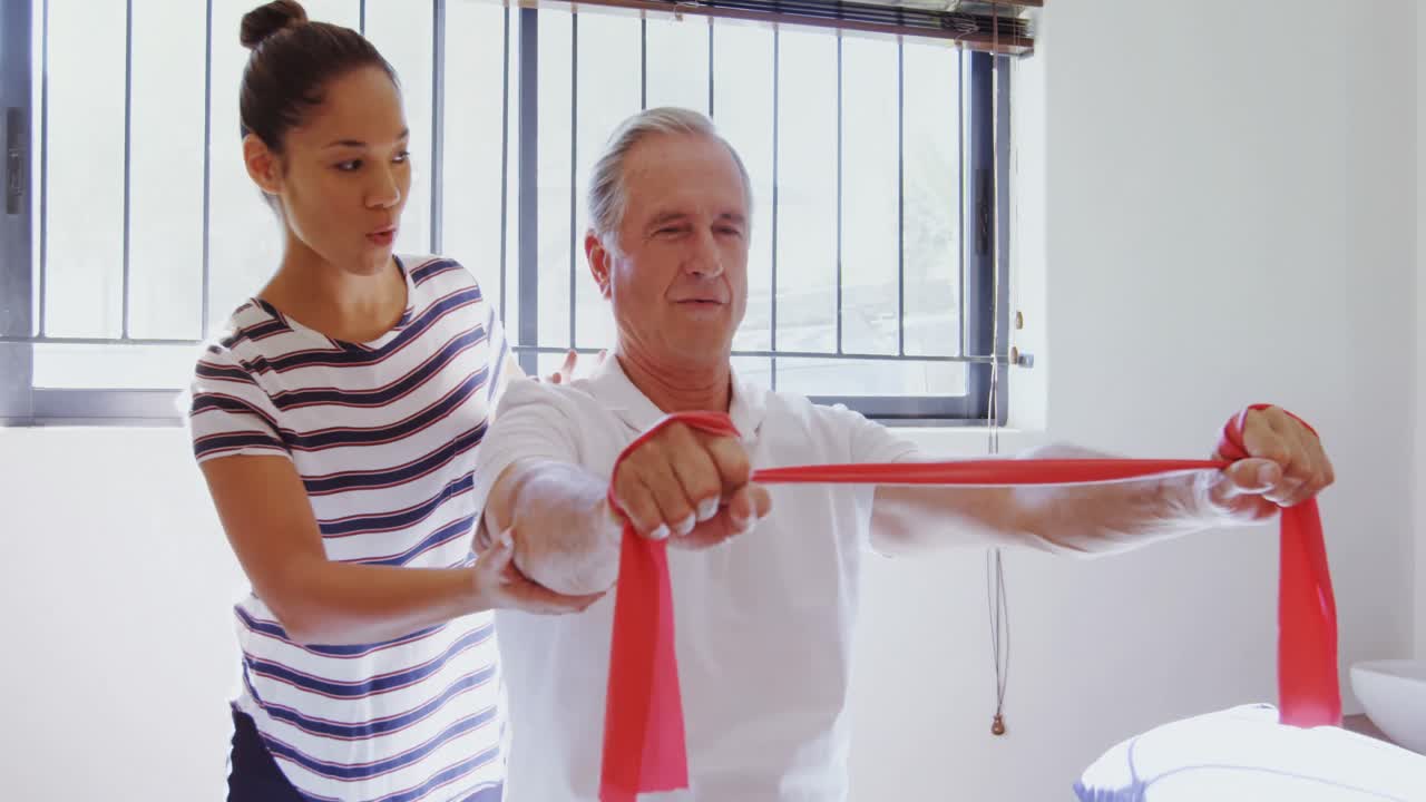 물리치료사가 4k 저항 범위의 운동을 수행하는 데 환자를 도와줍니다.