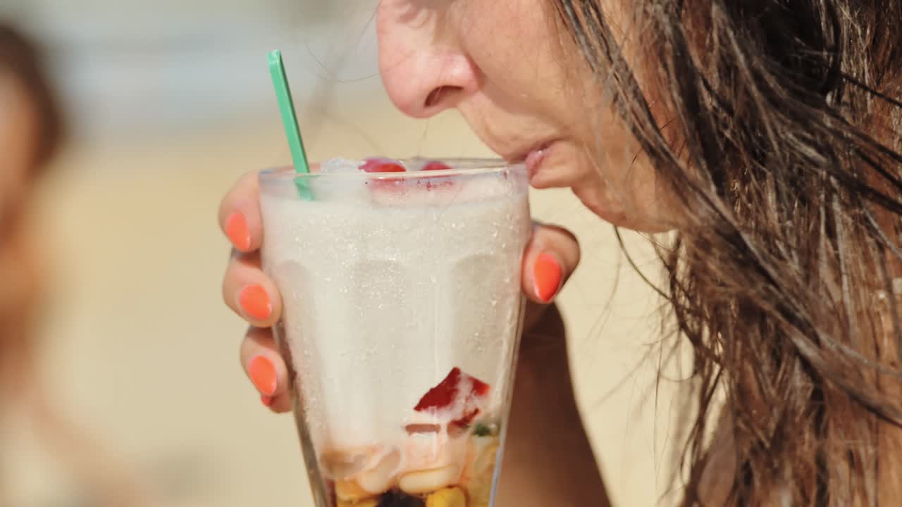 Bevanda tropicale rinfrescante gustata in spiaggia, che cattura un'atmosfera di vacanza rilassata.