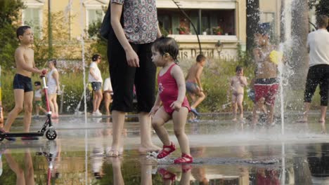 children playing at a city park water feature