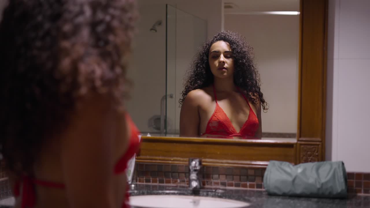 Una donna che si guarda nello specchio del bagno