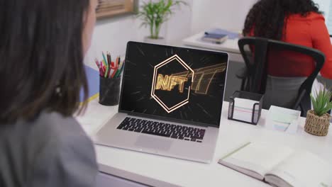 mujer de negocios biracial usando computadora portátil para videollamada con texto nft
